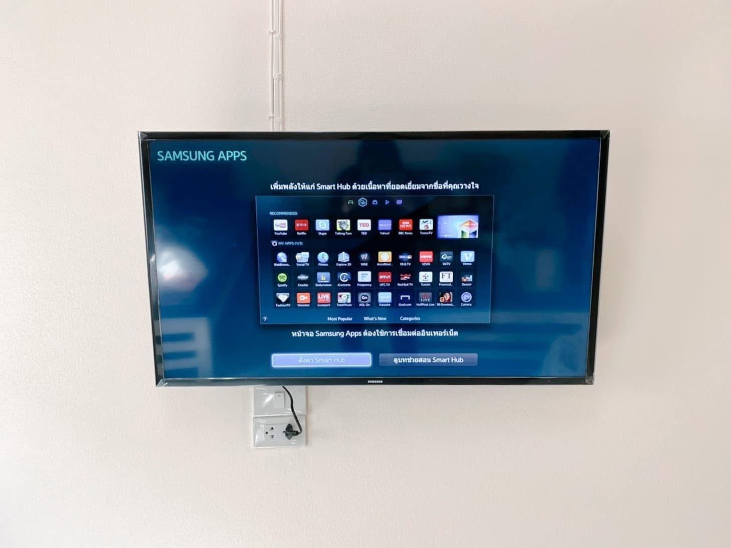 โทรทัศน์ Samsung Smart TV ติดผนังสีขาว แสดงหน้าจอแอปพลิเคชัน